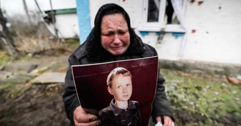 Mieszkanka podkijowskiej wsi pokazuje zdjęcie syna zamordowanego przez rosyjskich żołnierzy. Fot. BBC News/YouTube.com