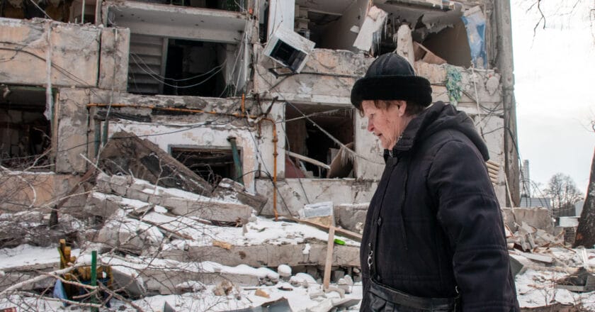 Mieszkanka Charkowa i zniszczony w rosyjskim ostrzale blok. Fot. Fotoreserg/Depositphotos