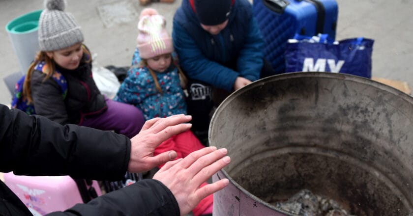 Uchodźcza rodzina rozgrzewa się przy koksowniku we Lwowie. Fot. Bumble-Dee/Depositphotos